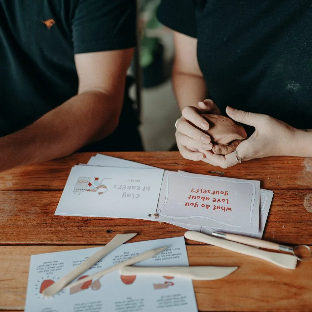 Couple asking each other questions using the clay breaker conversation cards